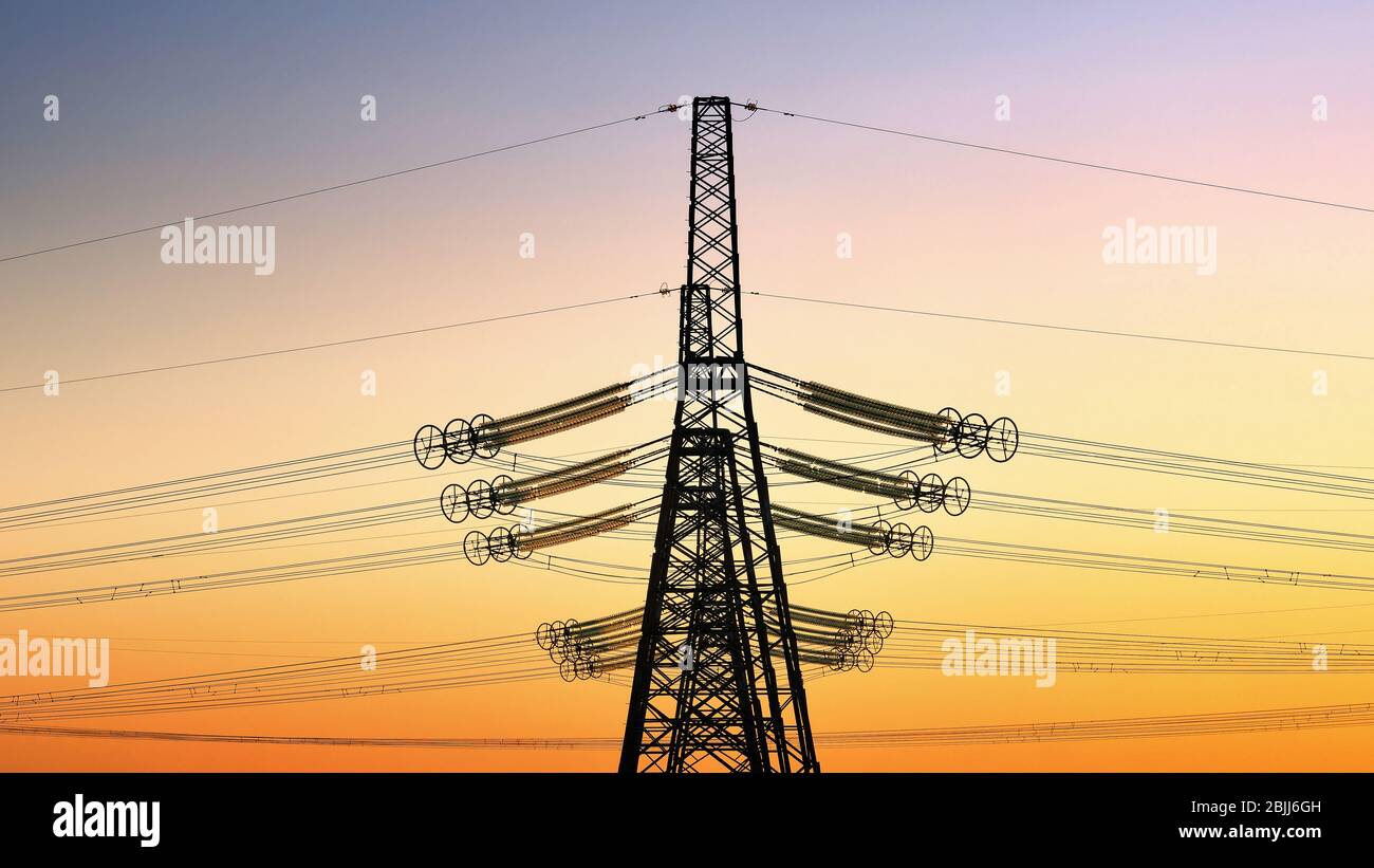 Torre elettrica ad alta tensione al tramonto. Tramonto cielo sfondo. Torre di alimentazione Foto Stock