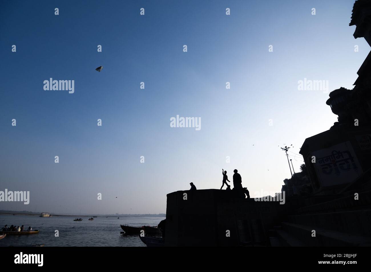 Il ragazzo vola kite sul ghat della città Santa di Varanasi, Uttar Pradesh, India. Foto Stock