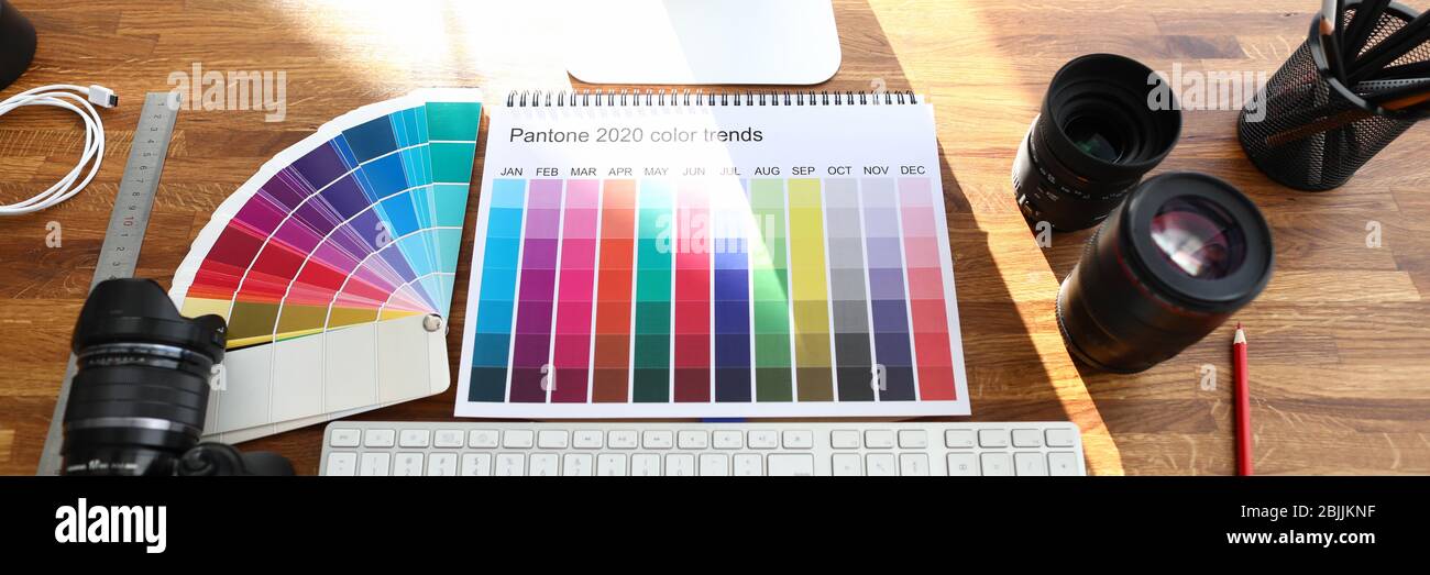 Libro di calendario a colori con le tendenze del colore segno sul tavolo di legno del progettista Foto Stock