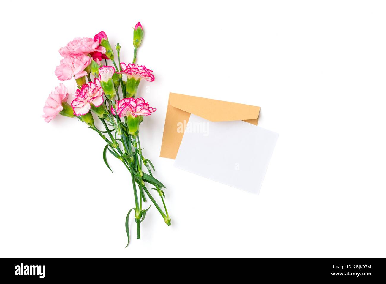 Bouquet colorato di diversi fiori di garofano rosa, busta artigianale, carta isolata su sfondo bianco Top view piatto laici Holiday card 8 marzo, felice Foto Stock