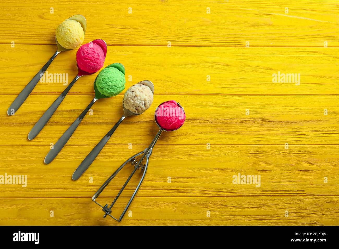Composizione con scoop colorati di gelato su sfondo legno Foto Stock