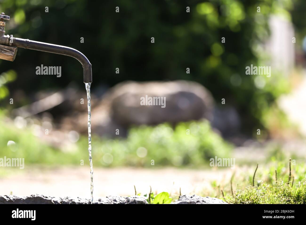 Rubinetto con acqua in acqua all'aperto. Concetto di scarsità d'acqua Foto Stock