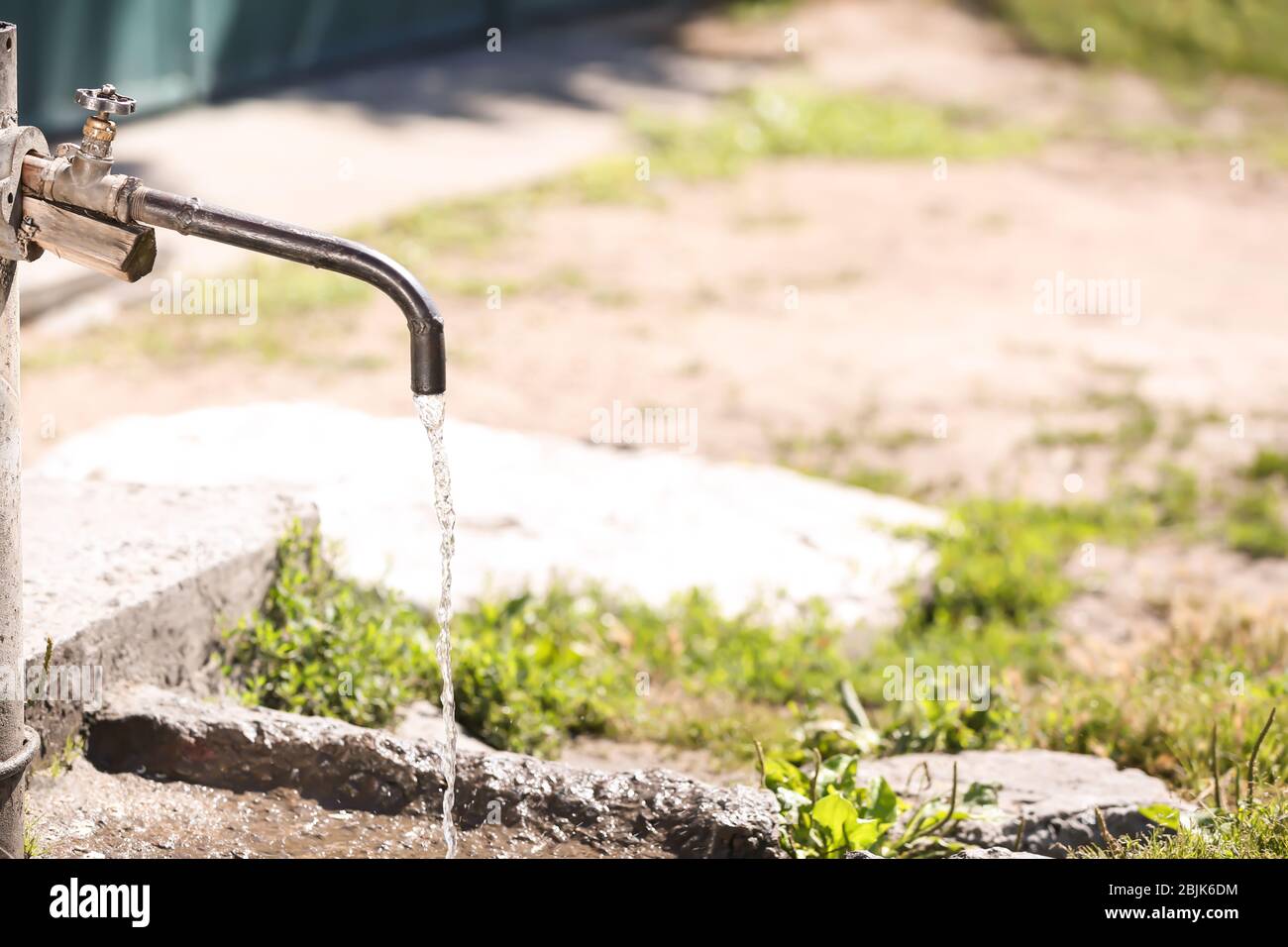 Rubinetto con acqua in acqua all'aperto. Concetto di scarsità d'acqua Foto Stock