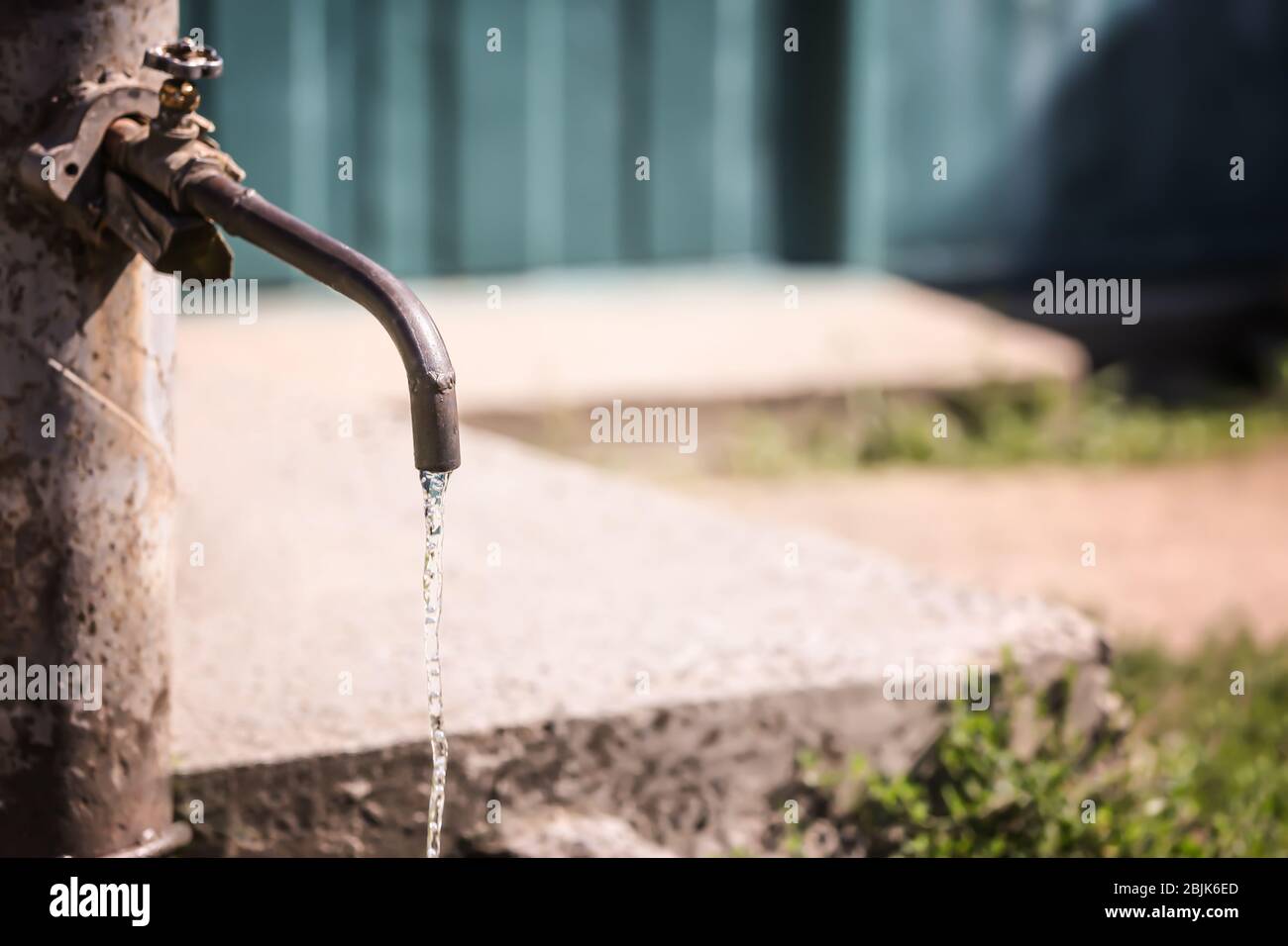 Rubinetto con acqua in acqua all'aperto. Concetto di scarsità d'acqua Foto Stock