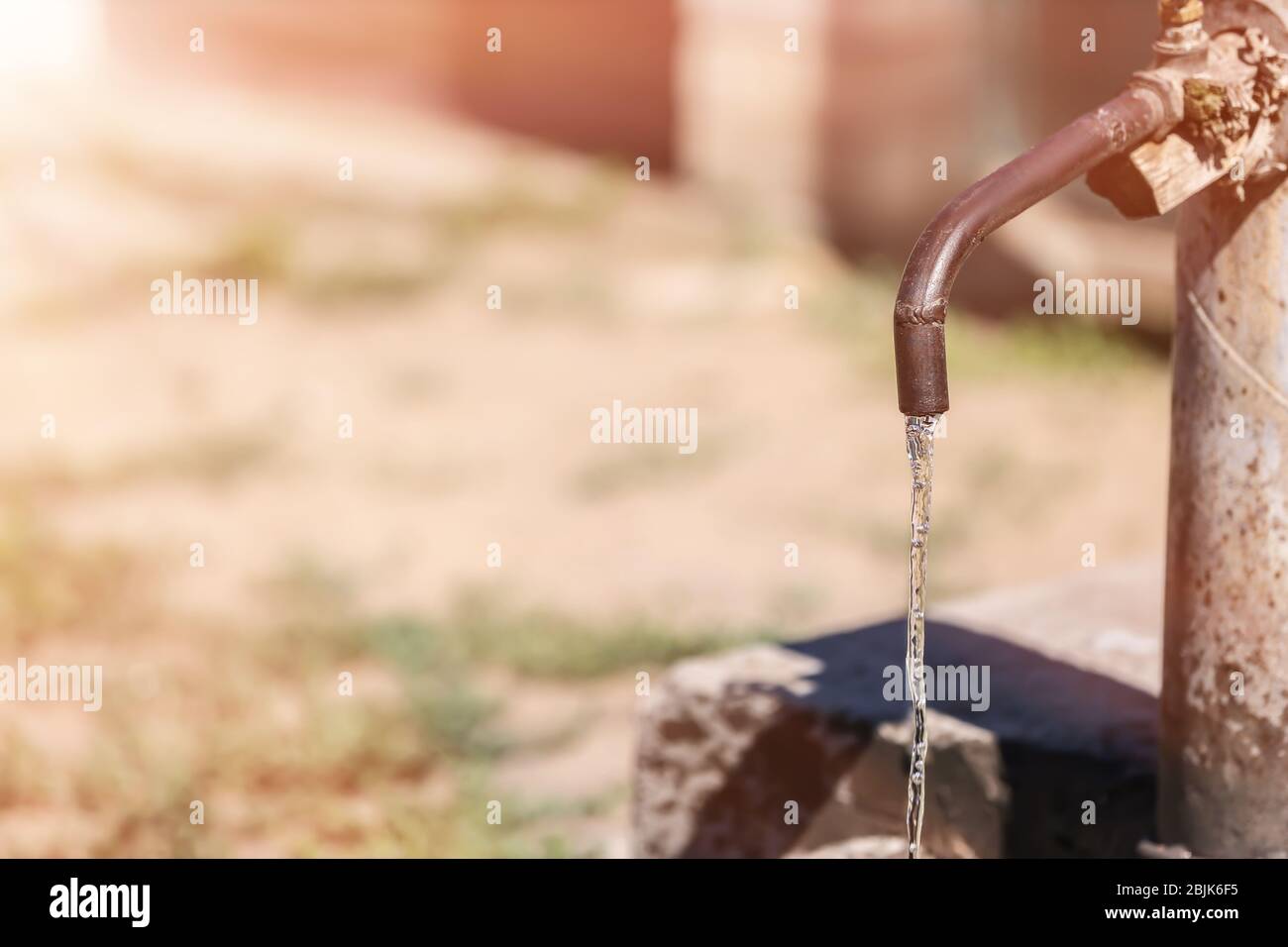 Rubinetto con acqua in acqua all'aperto. Concetto di scarsità d'acqua Foto Stock
