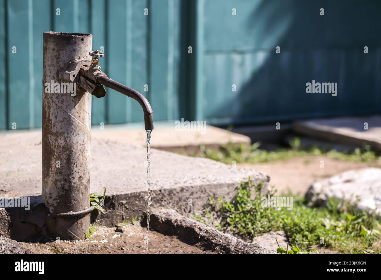 Rubinetto con acqua in acqua all'aperto. Concetto di scarsità d'acqua Foto Stock