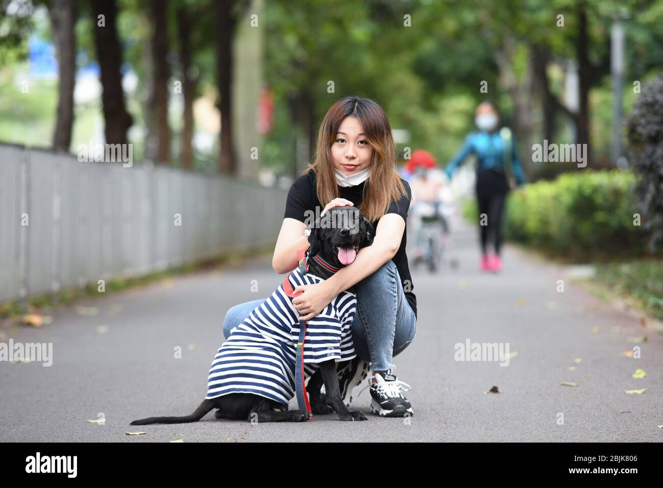 (200430) -- SHENZHEN, 30 aprile 2020 (Xinhua) -- li Wenqi pone per una foto con il suo cane adottato su un passaggio nel distretto di Longhua di Shenzhen, provincia di Guangdong della Cina meridionale, 24 aprile 2020. Li Wenqi, nato nel 1993, ha un lavoro nella moderna metropoli cinese meridionale di Shenzhen. Durante le tradizionali vacanze lunari di Capodanno quest'anno, li tornò per riunificazione familiare come di consueto alla sua città natale di Harbin, capitale della provincia di Heilongjiang della Cina nordorientale. Tuttavia, influenzato dall'improvvisa pandemia COVID-19, li non poteva tornare a Shenzhen dopo le vacanze e deve rimanere a casa come OTH Foto Stock