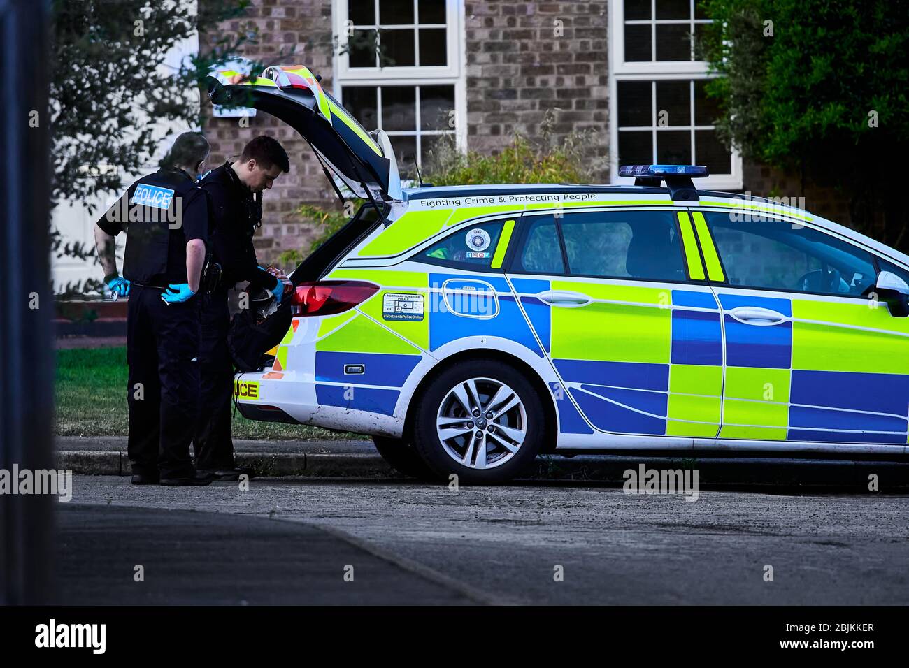 Due poliziotti del northamptonshire constabulary hanno messo oggetti confiscati nel bagagliaio della loro macchina di polizia durante il blocco del coronavirus. Foto Stock