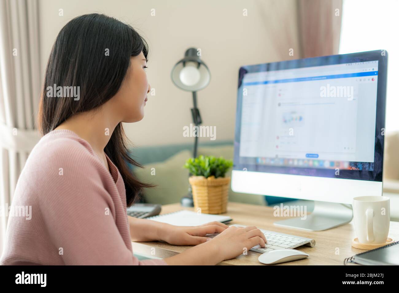 Donna asiatica d'affari che chiacchiera con i suoi colleghi circa il programma di lavoro nella stanza di chiacchierata. Un team aziendale multietnico che utilizza il computer per una riunione online. Gruppo di Foto Stock