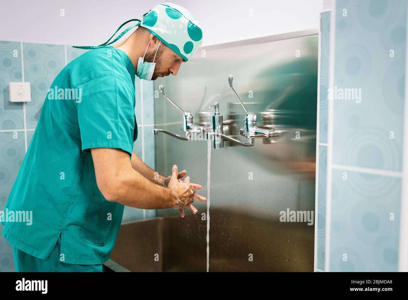 Il chirurgo lavando le mani al funzionamento utilizzando la tecnica corretta per la pulizia Foto Stock