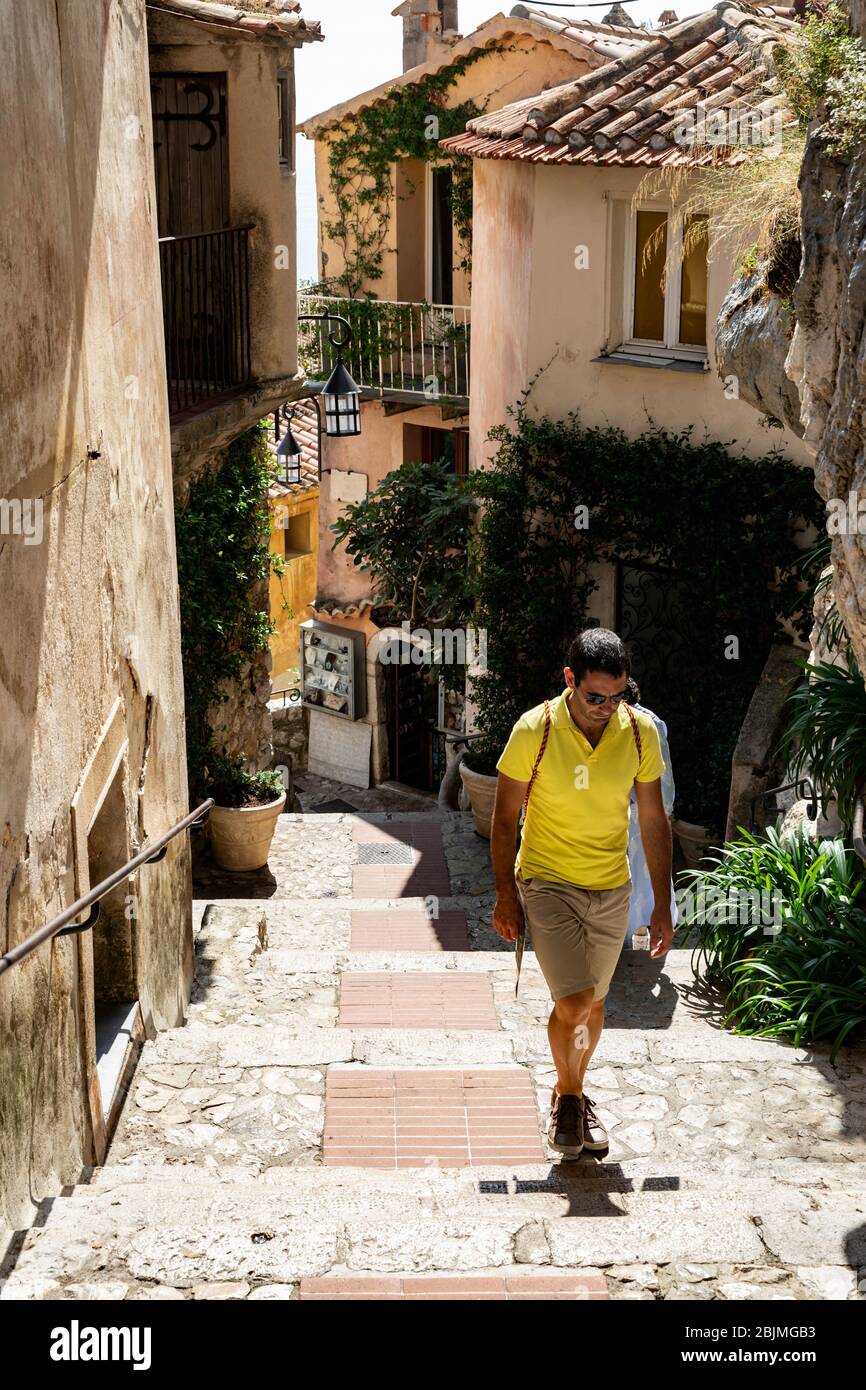 Turista che esplora le strette viuzze di Eze, Costa Azzurra, Provenza, Francia. Foto Stock