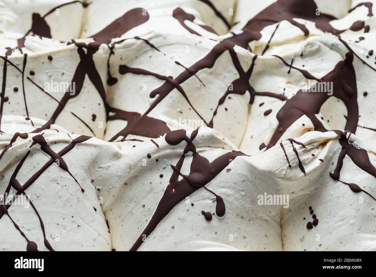 Stracciatella sapore gelato - dettaglio cornice. Primo piano di una superficie bianca di stracciatella gelato ricoperto di strisce di cioccolato e do Foto Stock
