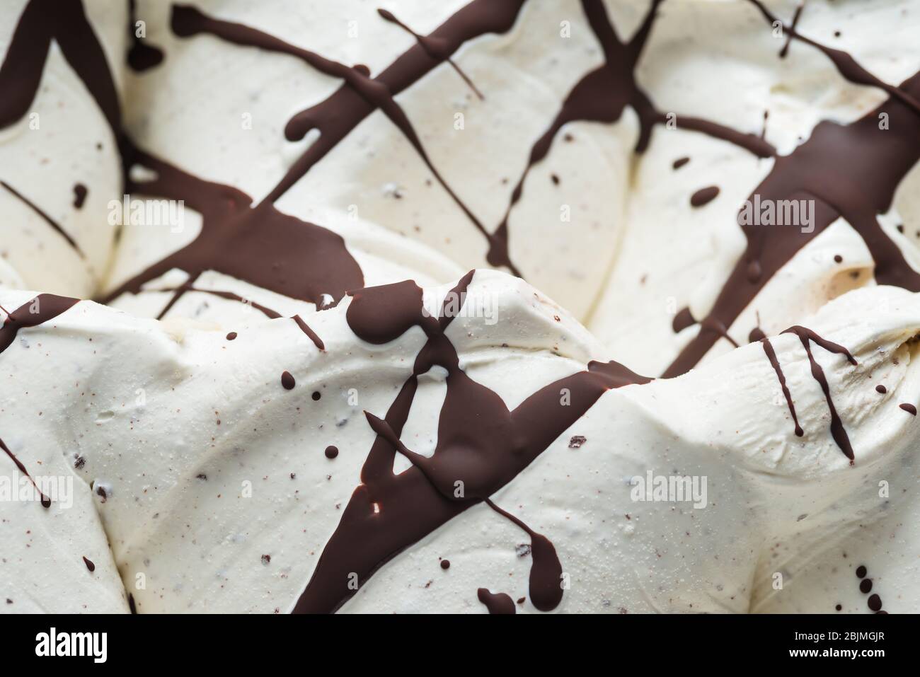 Stracciatella sapore gelato - dettaglio cornice. Primo piano di una superficie bianca di stracciatella gelato ricoperto di strisce di cioccolato e do Foto Stock