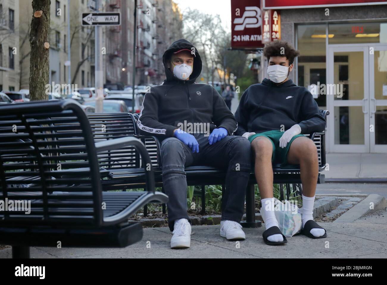 Due amici indossano maschere e guanti durante lo scoppio e il confinamento del Covid-19 Foto Stock