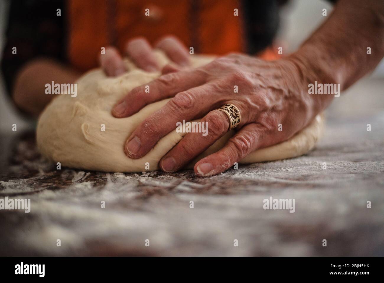 Primo piano delle mani di una donna anziana impastando il pane Foto Stock