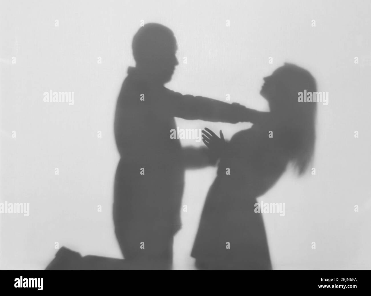 Silhouette di uomo che cerca di uccidere sua moglie su sfondo bianco. Concetto di violenza domestica Foto Stock