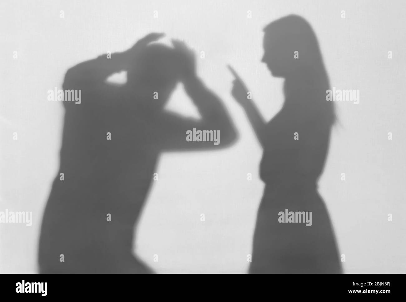 Silhouette di donna che incolpa suo marito su sfondo bianco. Concetto di violenza domestica Foto Stock