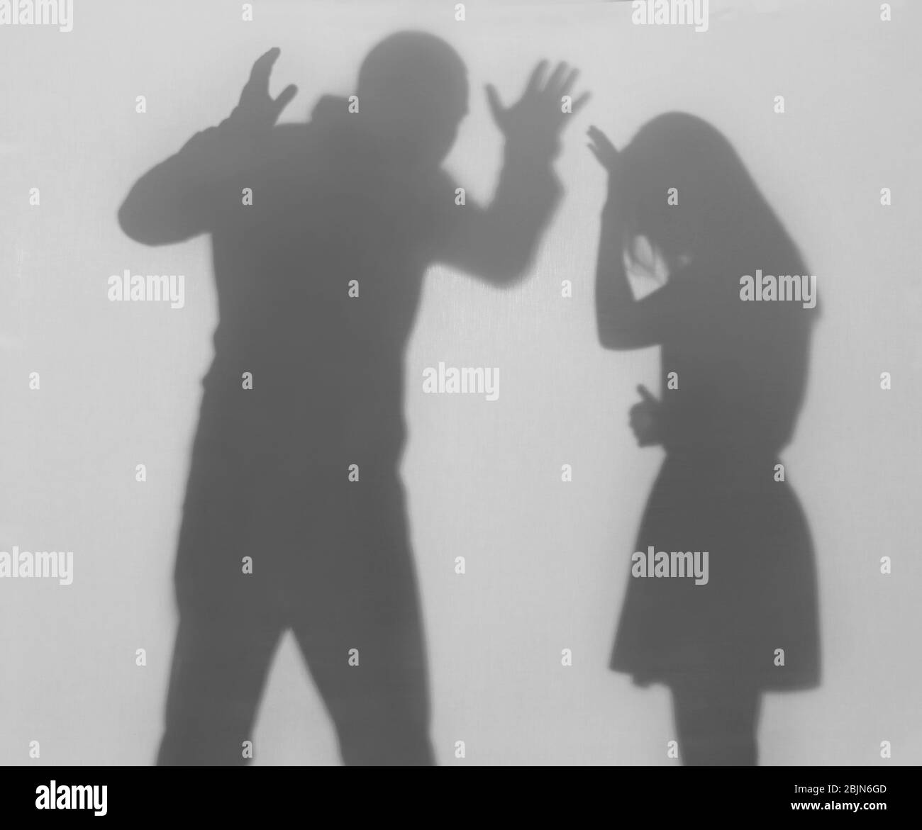Silhouette di uomo e donna in litigazione su sfondo bianco. Concetto di violenza domestica Foto Stock