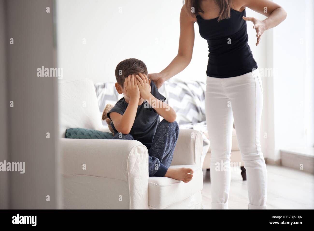 Donna che sgrida il figlio a casa. Concetto di violenza domestica Foto Stock