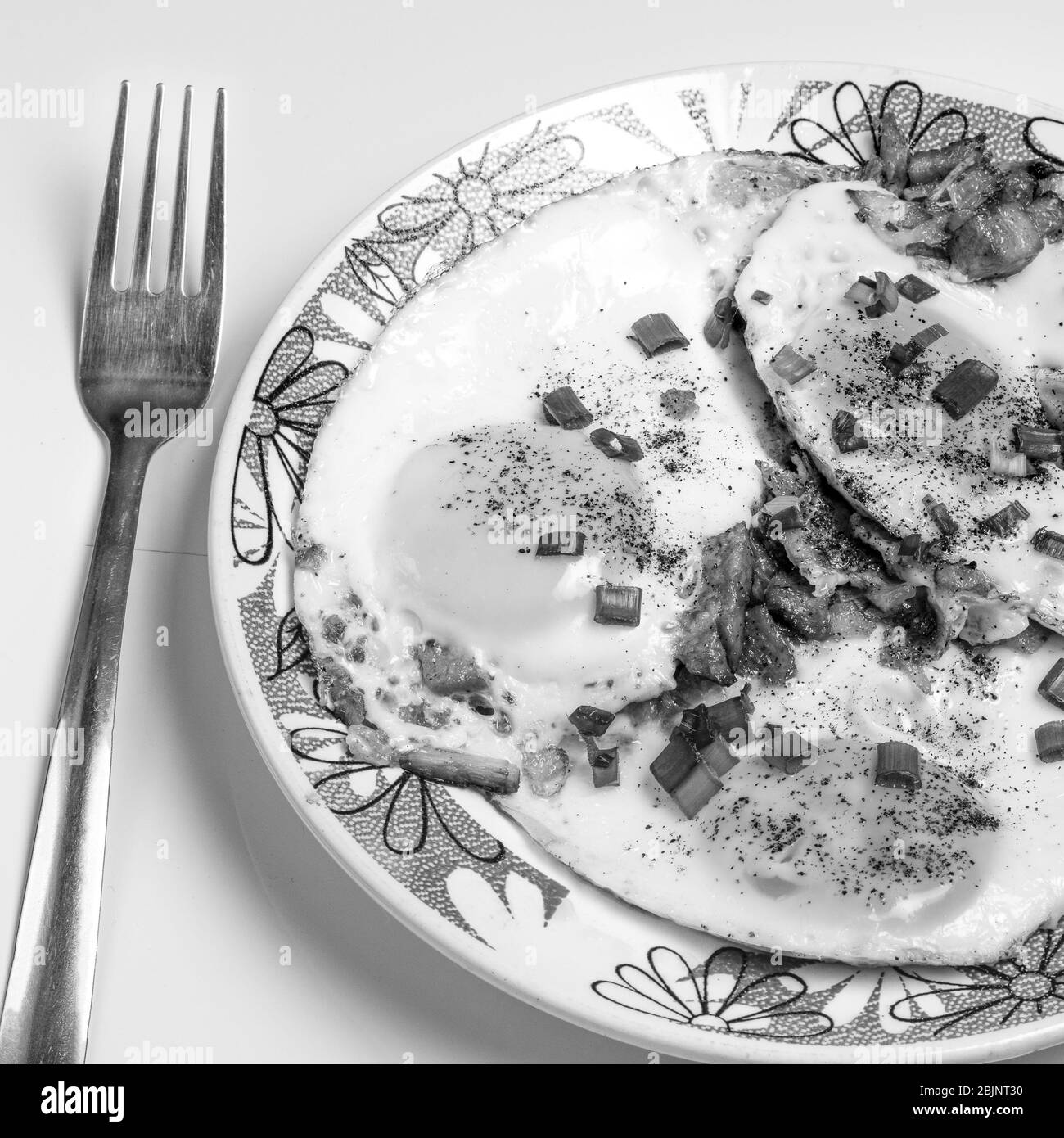 Nella foto è raffigurato un primo piano di uova fritte, con un supplemento di pepe e cipolle verdi. Foto Stock