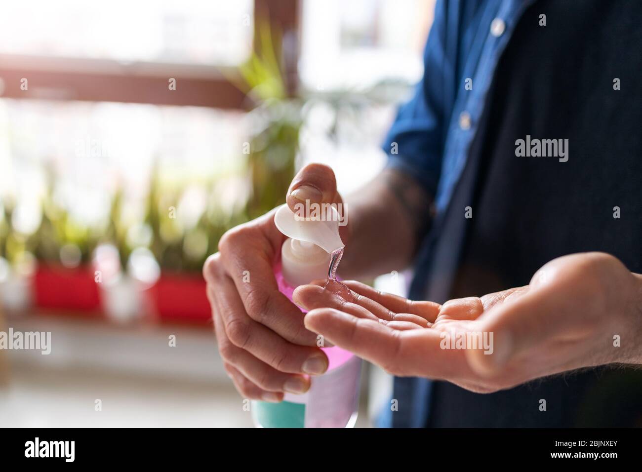 Primo piano di un uomo che dispensa igienizzante per le mani Foto Stock