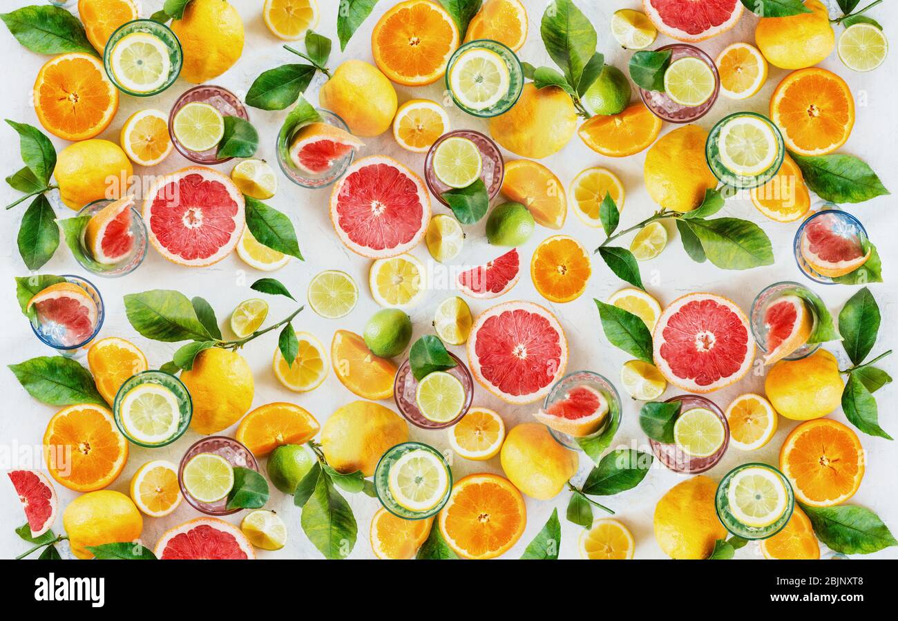 Fondo di agrumi con semi e fette di agrumi vari con foglie verdi. Vista dall'alto. Disposizione piatta. Mangiare sano. Vitamina. Bere Foto Stock