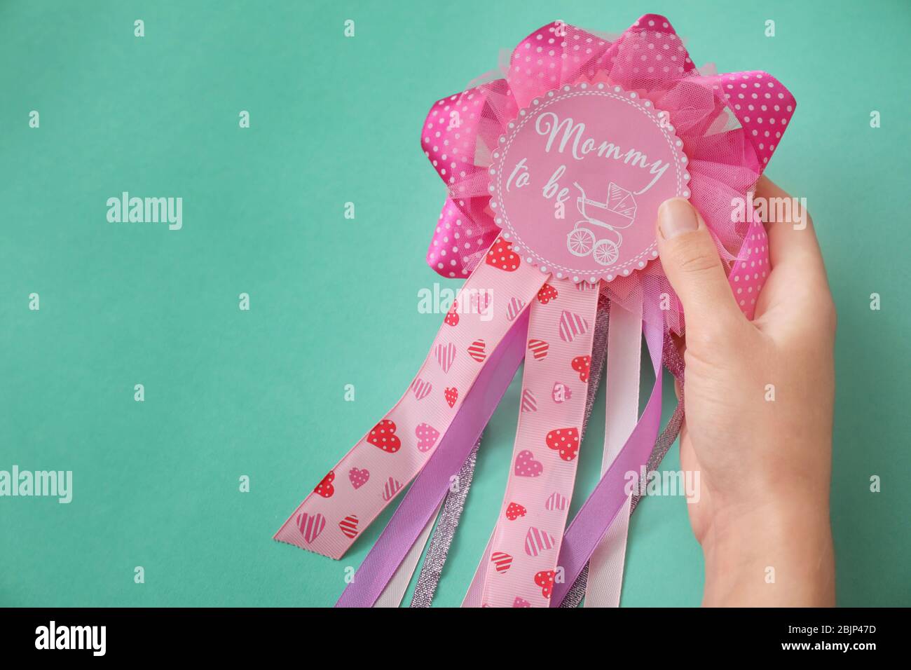 Donna che tiene nastro premio con MUMMY testo PER ESSERE su sfondo colore Foto Stock