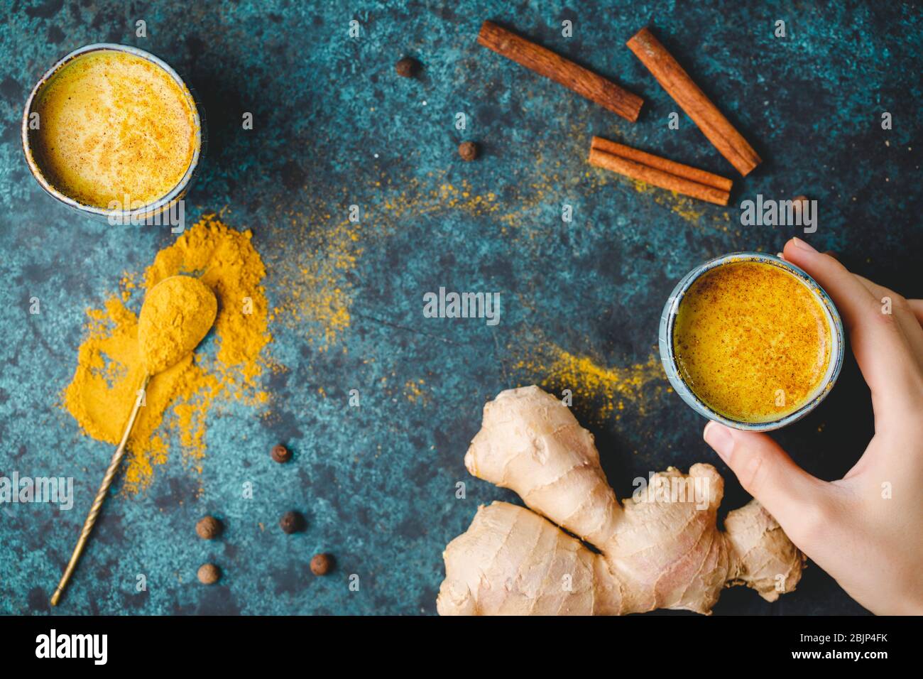 Vista dall'alto del latte curcuma, zenzero, cannella e allspezia. Bevanda immune e sanitaria. Foto Stock