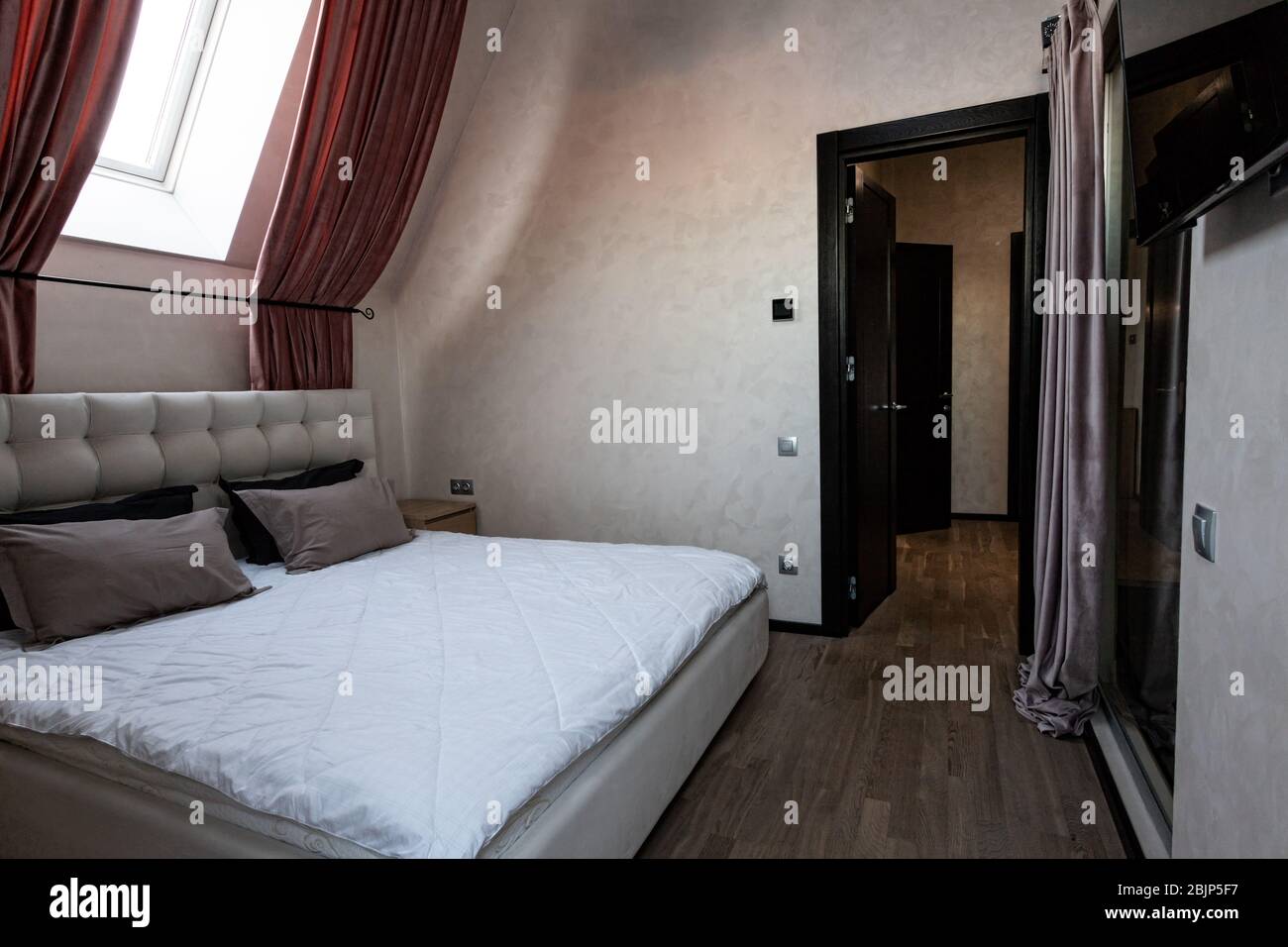 Interni eleganti e moderni della camera con un letto grande e confortevole Foto Stock