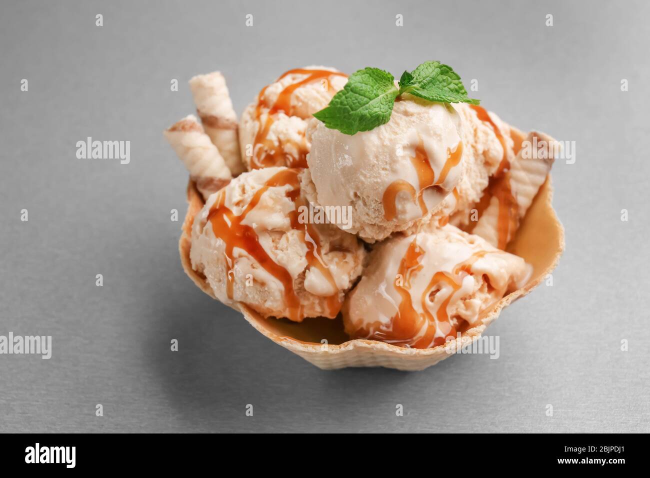 Ciotola per waffle con gelato al caramello su sfondo grigio Foto stock -  Alamy