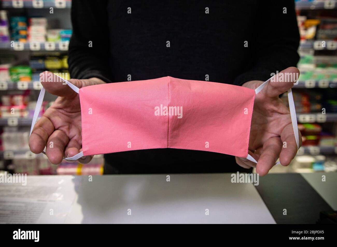 Parigi, Francia. 29 aprile 2020. Un membro dello staff mostra una maschera facciale in tessuto presso una farmacia a Parigi, Francia, 29 aprile 2020. Il numero di morti di coronavirus in Francia è salito a 24,087 mentre le ospedalizzazioni e i pazienti in terapia intensiva hanno continuato a diminuire mercoledì. Credit: Aurelien Morissard/Xinhua/Alamy Live News Foto Stock