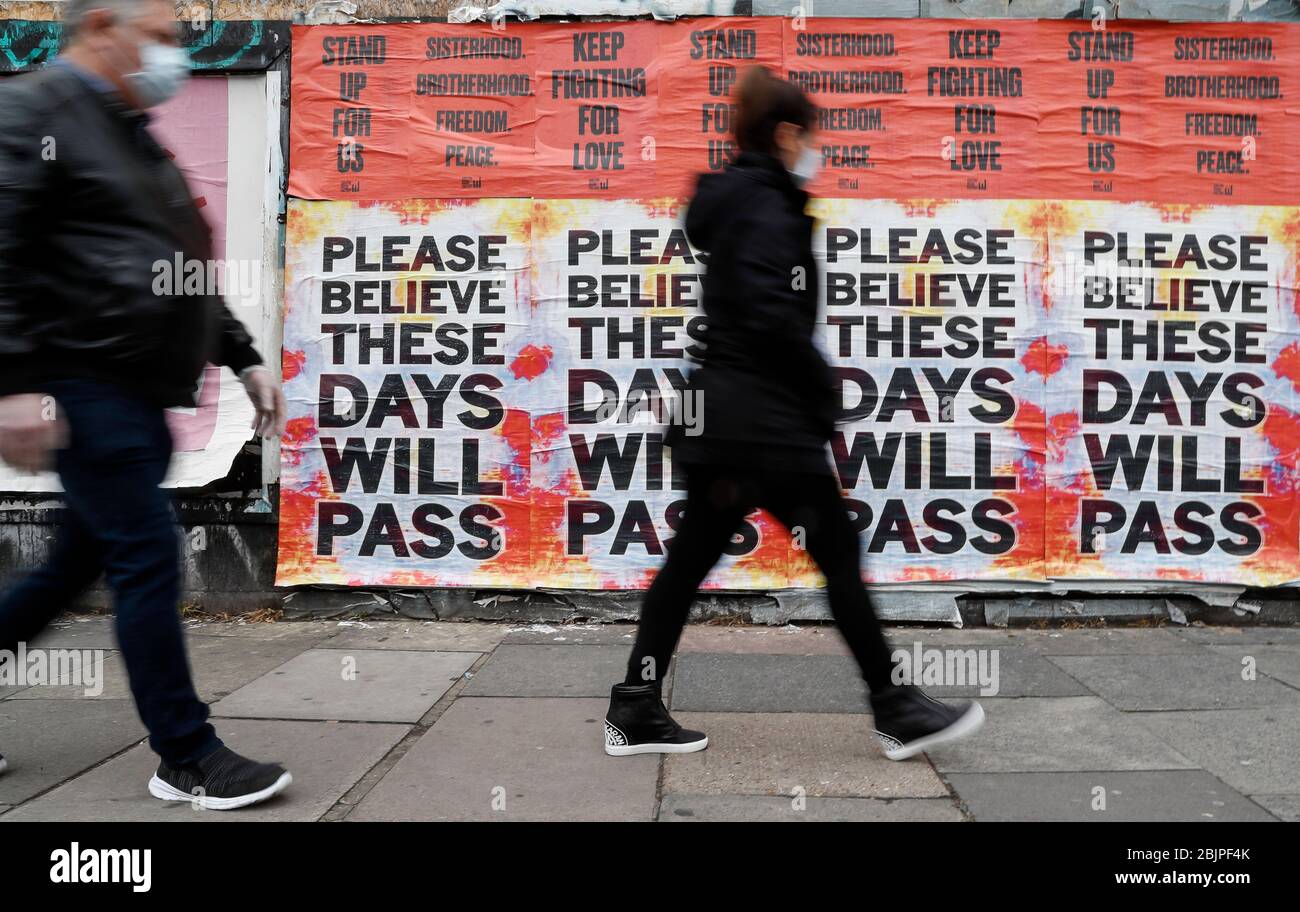 Londra, Regno Unito. 30 Aprile 2020. La gente cammina davanti a manifesti che incoraggiano la gente ad avere fede durante l'epidemia di coronavirus a Londra, in Gran Bretagna, il 30 aprile 2020. Credit: Han Yan/Xinhua/Alamy Live News Foto Stock