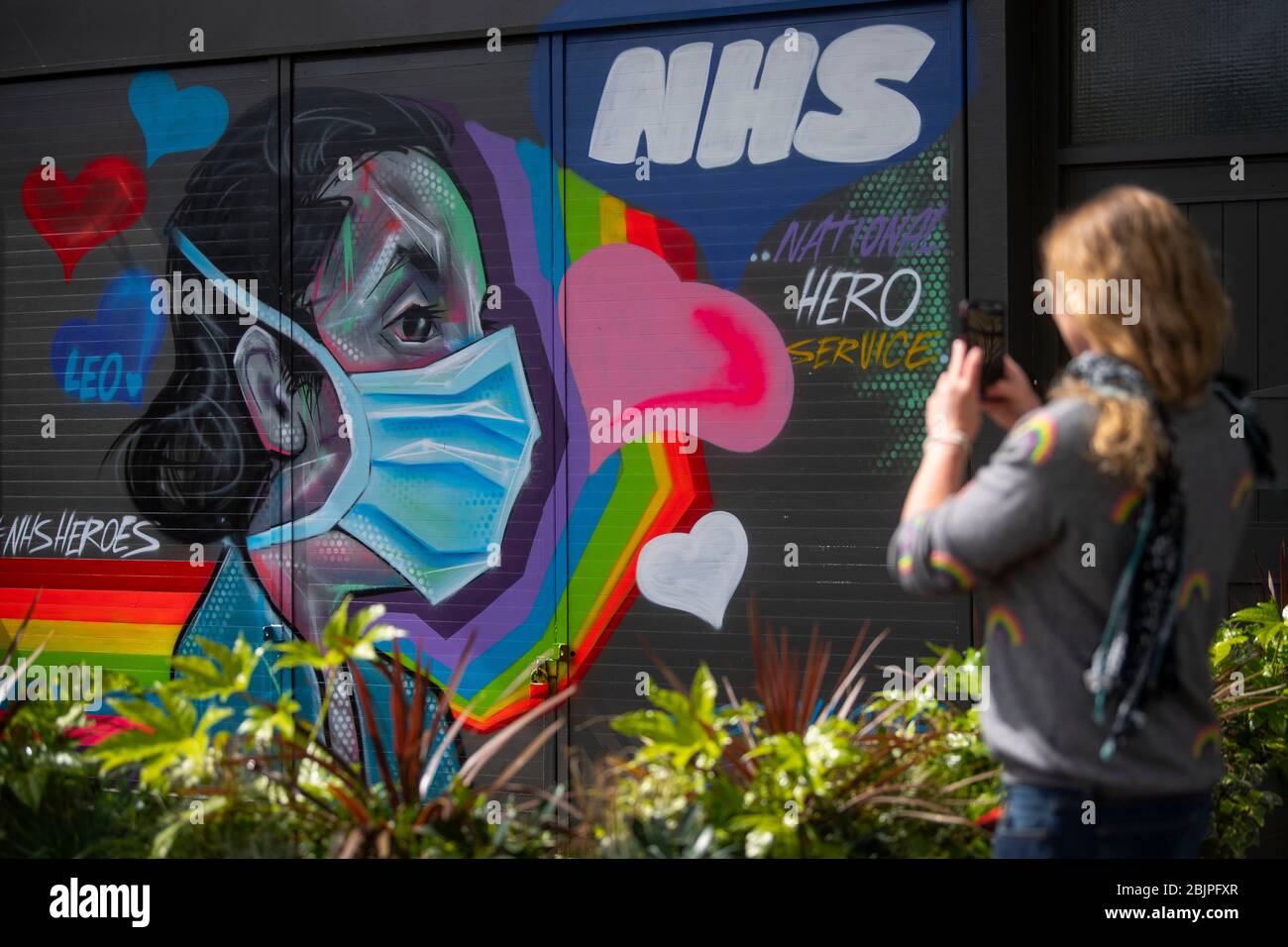 Una donna prende una fotografia di graffiti a sostegno del NHS nel sud-est di Londra, mentre il Regno Unito continua a bloccare per contribuire a frenare la diffusione del coronavirus. Foto Stock