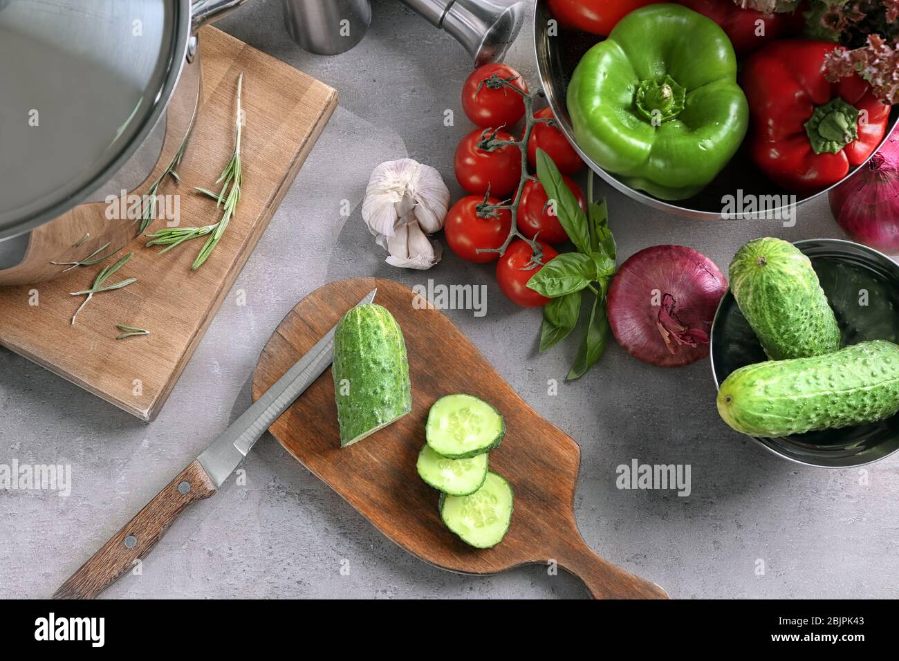 Composizione con utensili da cucina e verdure in tavola Foto Stock