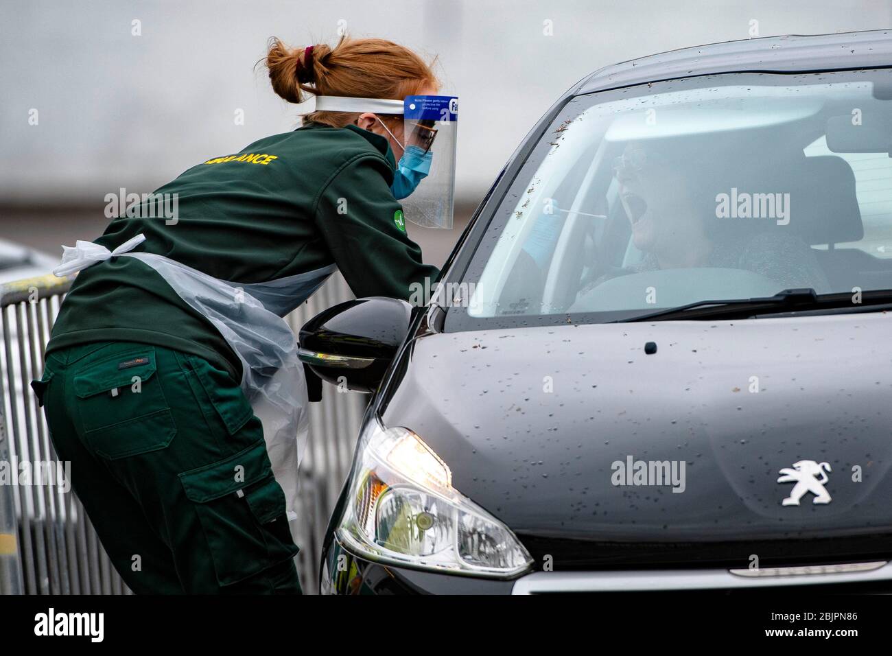 Una donna viene inghiottita per un test di coronavirus presso la stazione mobile di test di coronavirus presso lo stadio Ashton Gate di Bristol, Regno Unito. Foto Stock