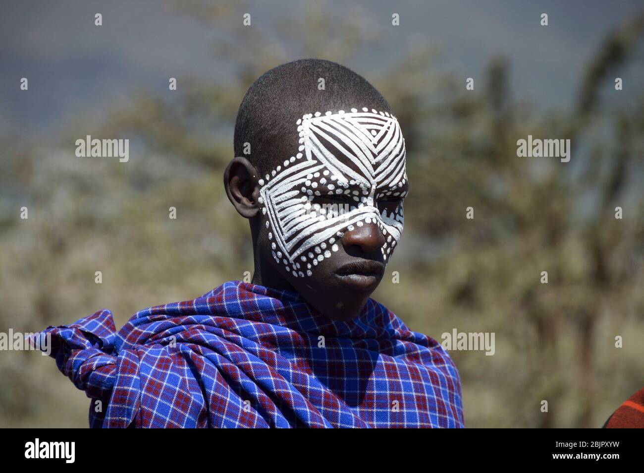 Un adolescente Maasai con faccia dipinta dopo la cerimonia 'emorata', che è la circoncisione e il diritto di passaggio per diventare un membro del guerriero o ' Foto Stock
