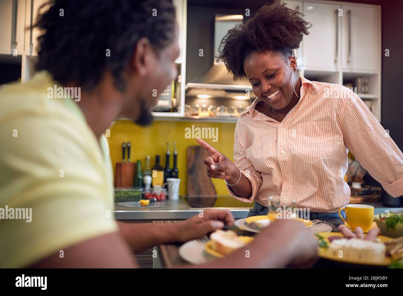 giovane coppia afro-americana che ha un interessante conversazione in cucina a tavola Foto Stock