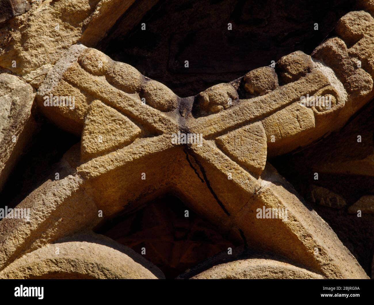 Valle Crucis Abbey, Llangollen, Galles, UK: Il tracery ornamentale e il volto di un monaco (?) Sullo schermo dell'armadio del chiostro nella gamma E. Foto Stock