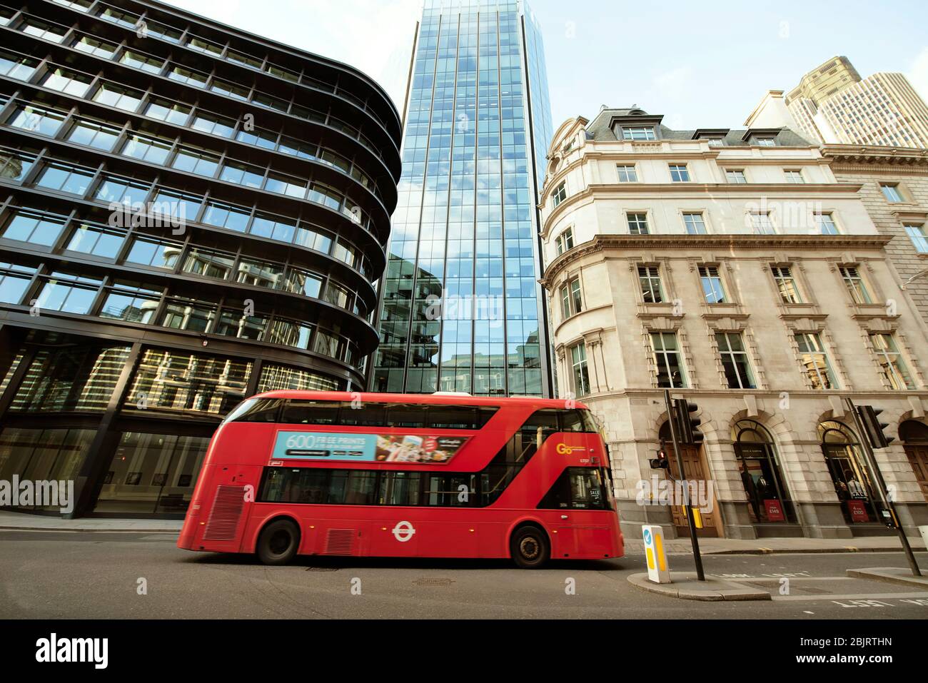 La città di Londra (Threadneedle Street / Old Broad St). Scatto architettonico grandangolare con autobus vuoto che passa la strada durante la chiusura. Mar 2020 Foto Stock