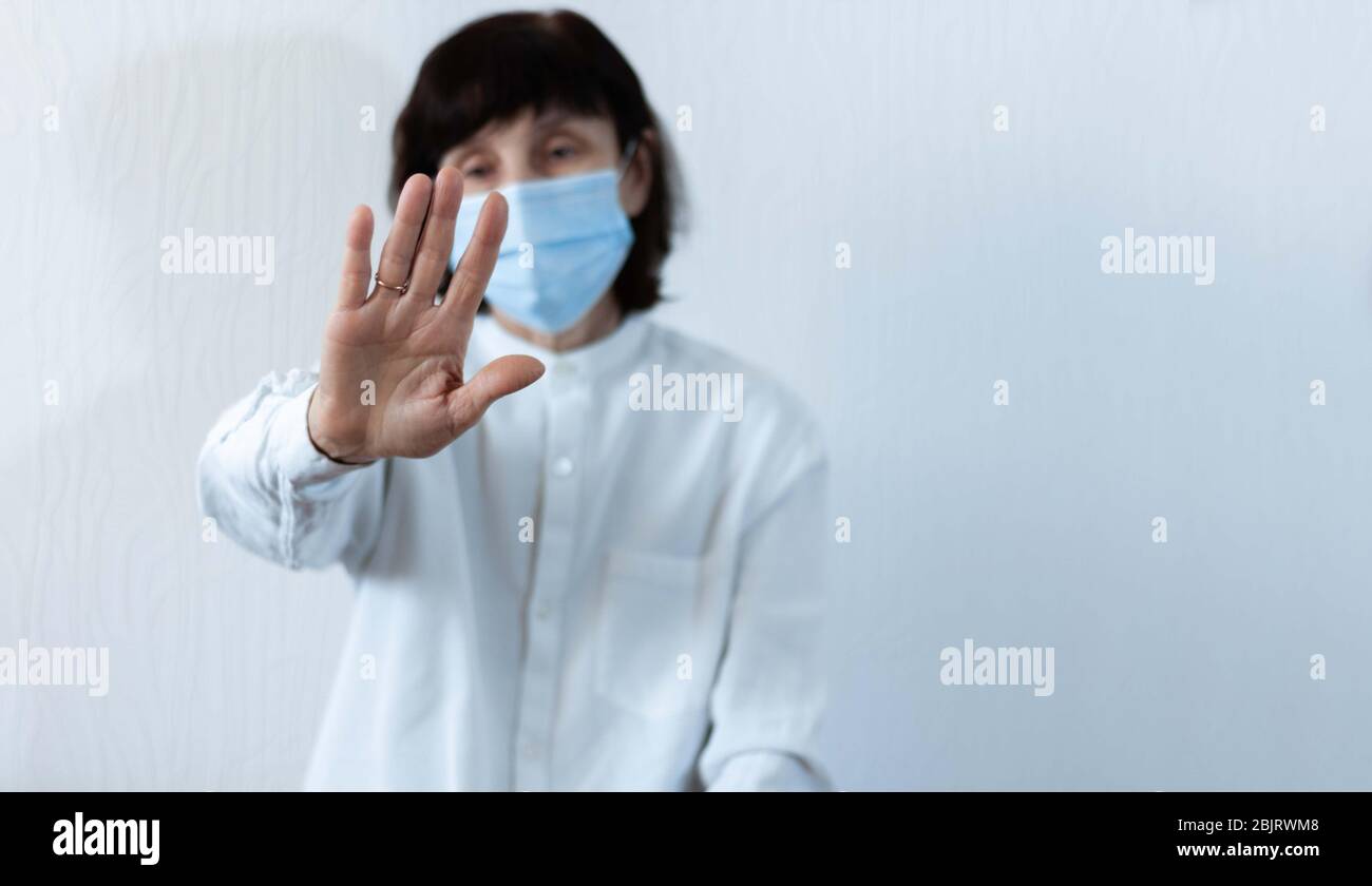 Quarantena del coronavirus e inquinamento atmosferico pm2.5 concetto. Vecchia donna malata che indossa maschera respiratore blu per proteggere con braccio allungato. Wuhan, Cina ep Foto Stock