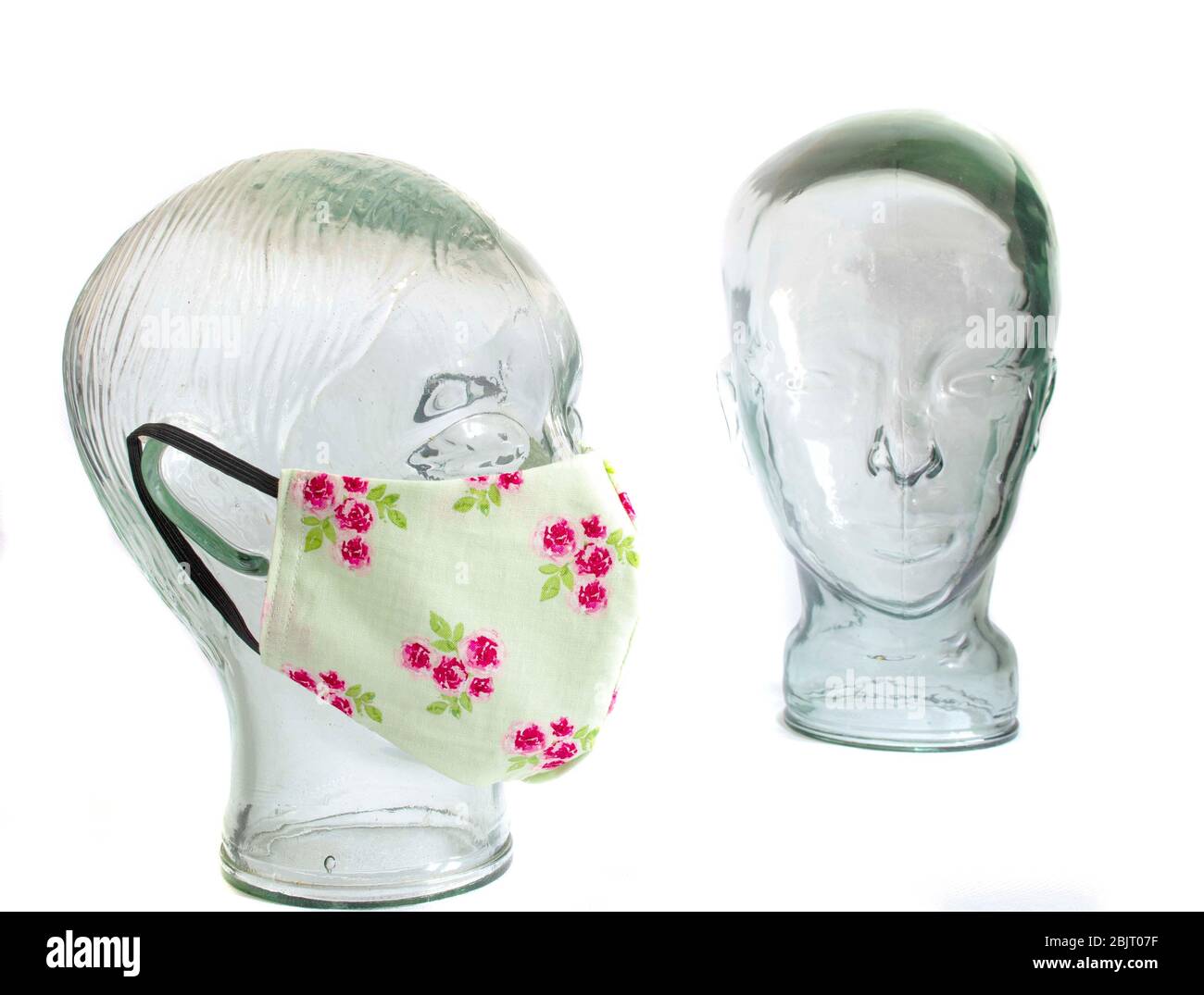 Maschere facciali di protezione su una testa in vetro senza volto DPI dispositivi di protezione individuale con fondo bianco Foto Stock