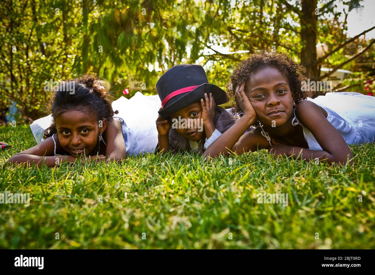 Gioventù elegante - i partecipanti a un matrimonio nel Parco pubblico di Shalla ad Addis Abeba si riprenderanno dalla cerimonia che giace nell'erba del parco. Foto Stock
