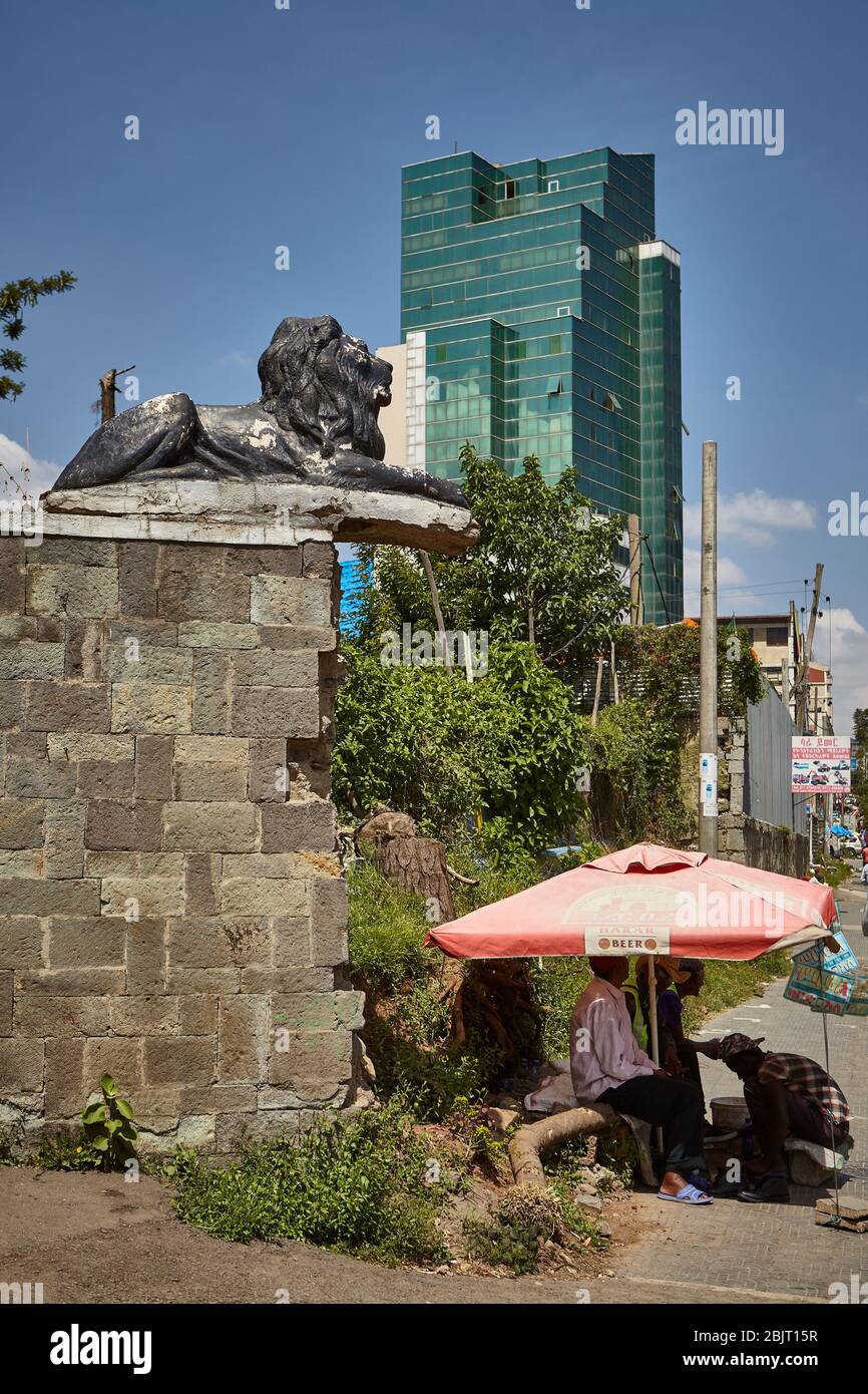 La statuina del leone non poggia su una solida terra. E' il momento di scappare con le nuove torri di vetro nella città di Addis Abeba. Foto Stock