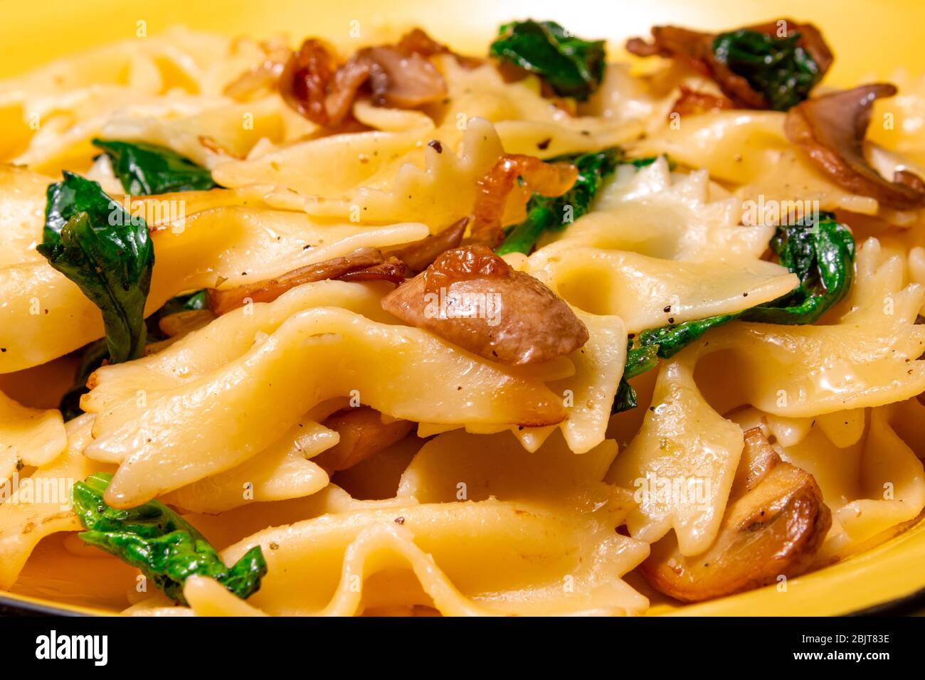 pasta farfalla con funghi fritti, spinaci verdi Foto Stock