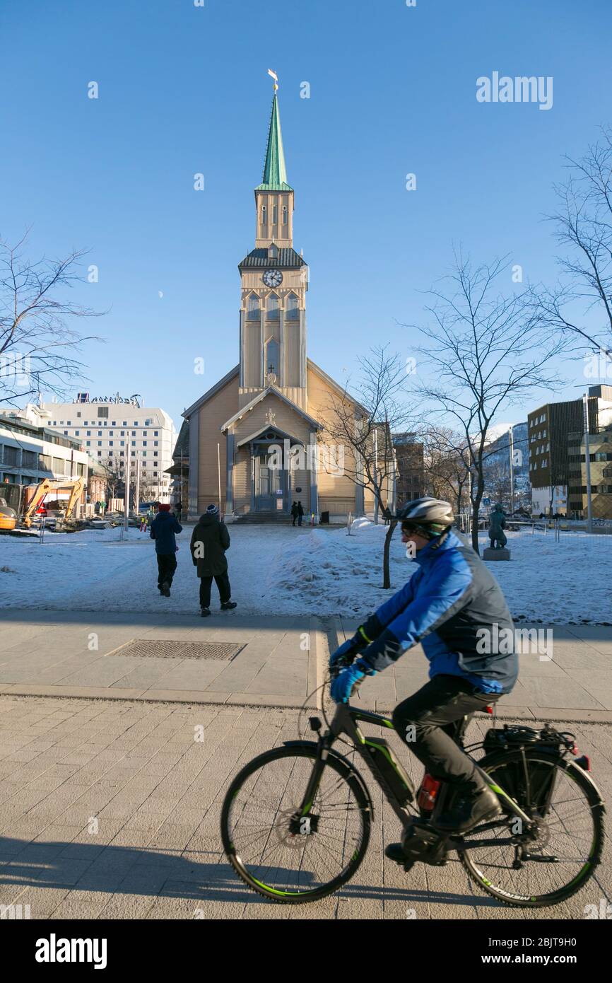 Uomo in bicicletta passando davanti alla Cattedrale di Tromsø, Tromsø, Norvegia Foto Stock