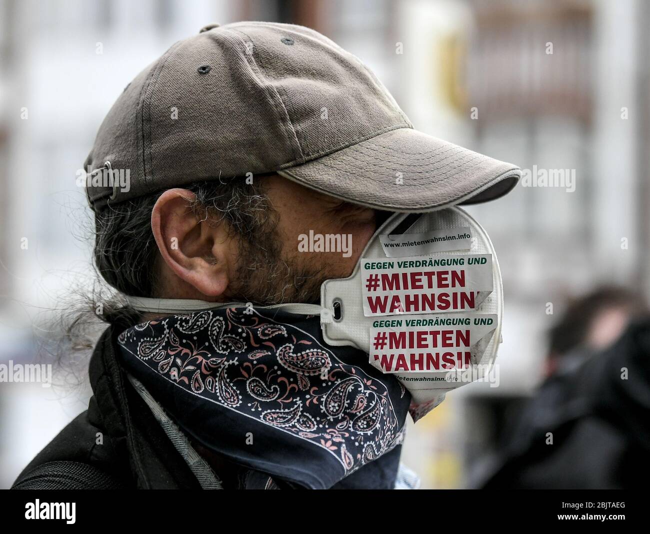 Berlino, Germania. 30 Aprile 2020. Un dimostratore indossa una guardia del boccaglio su Leopoldplatz prima della notte di Walpurgis, alla quale è attaccata una sticker con l'iscrizione 'Gegen Verdrängung und mieten Wahnsinn' (contro la repressione e l'affitto di follia). Anche sotto l'impressione della pandemia di Corona, intorno al 1° maggio si sono svolte manifestazioni. Credit: Brittta Pedersen/dpa-Zentralbild/dpa/Alamy Live News Foto Stock