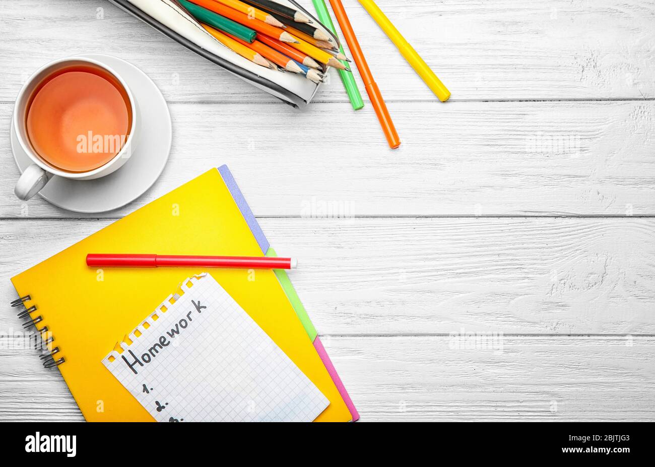 Foglio di carta con la parola 'Homework', tè e cancelleria su sfondo di legno, vista dall'alto Foto Stock