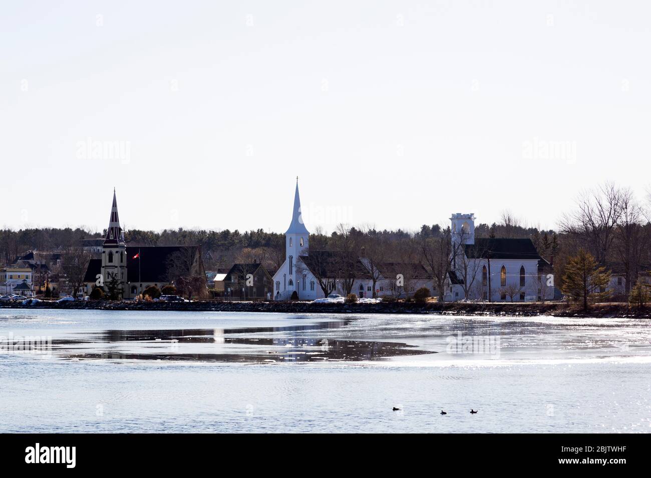 Vista delle tre chiese della Baia di Mahone in Nuova Scozia, Canada. Il è visto attraverso un ingresso parzialmente congelato in una giornata invernale. Foto Stock