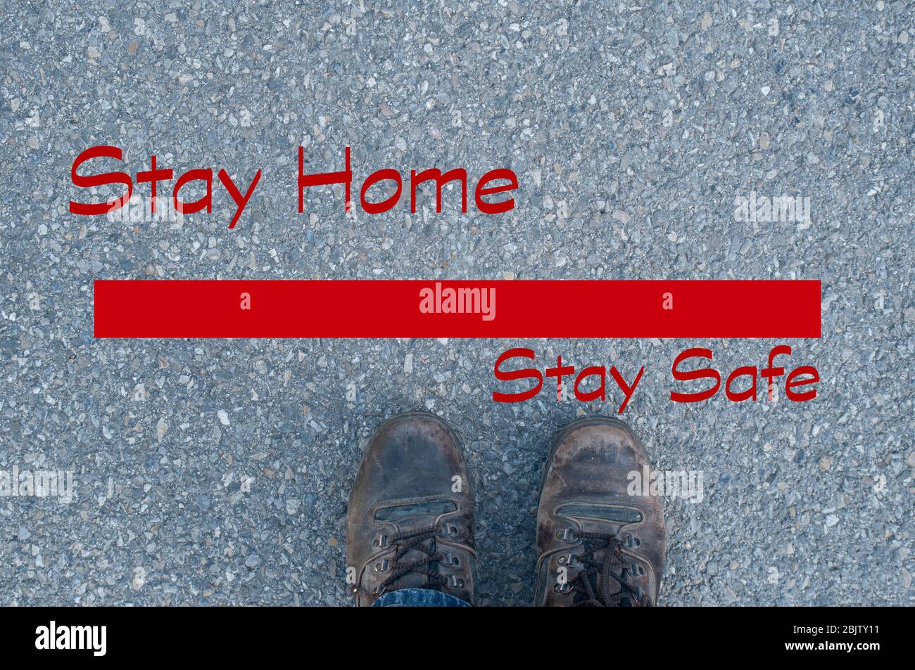 scarpe da passeggio davanti linea rossa, rimanere a casa stare al sicuro. scrittore in rosso. su strada asfaltata. Covid 19.Concept aiutare i nostri medici Foto Stock