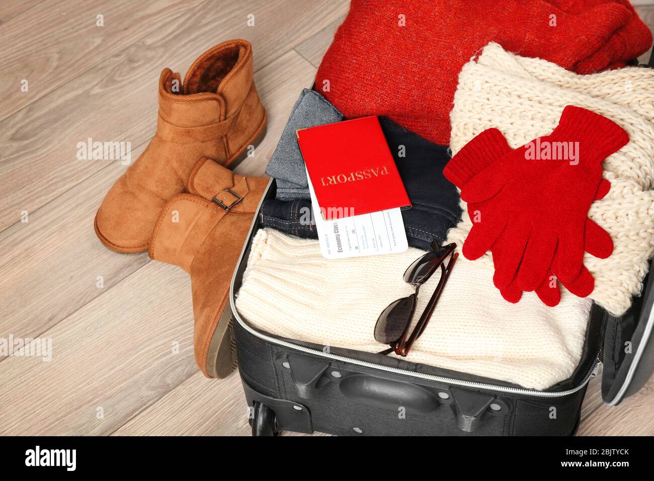 Aprire la valigia con vestiti caldi e documenti su pavimento di legno.  Vacanza invernale concept Foto stock - Alamy